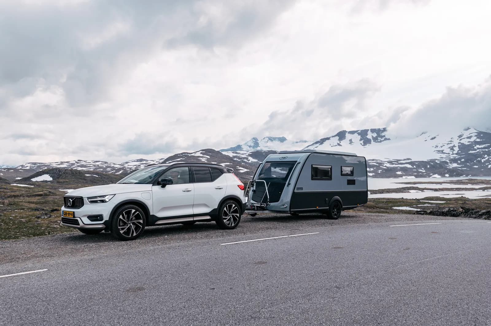 Kip caravan achter een witte SUV in de Noorse bergen