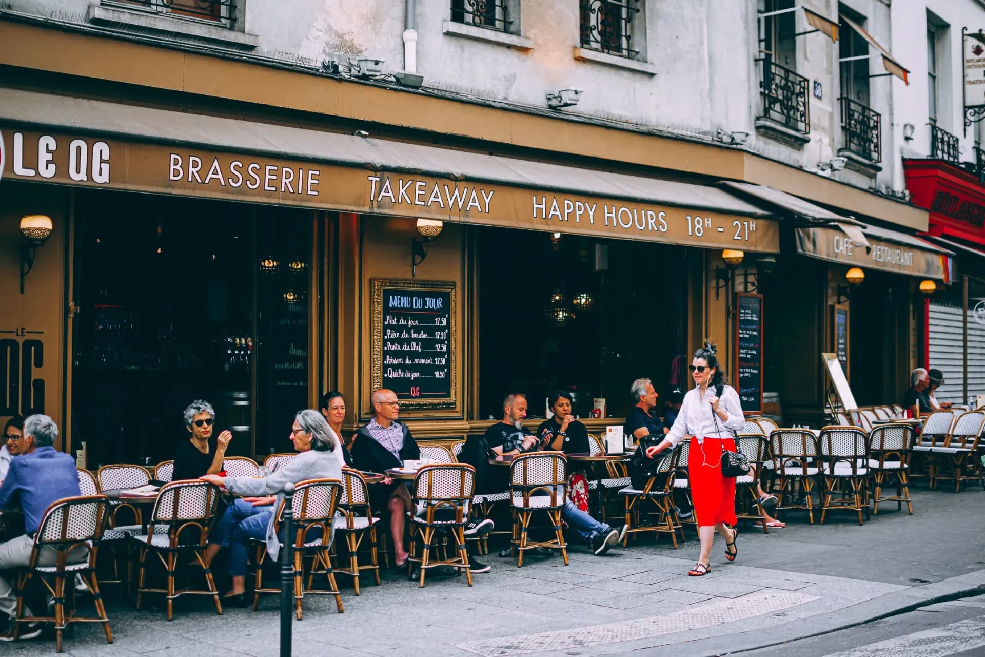 Terras van een Parijse brasserie met gasten en rode details